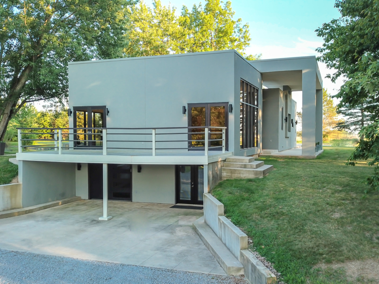 Exterior of modern renovation home project by The RBT Group features crisp lines, grey and black color pallet, and sleek lighting features.