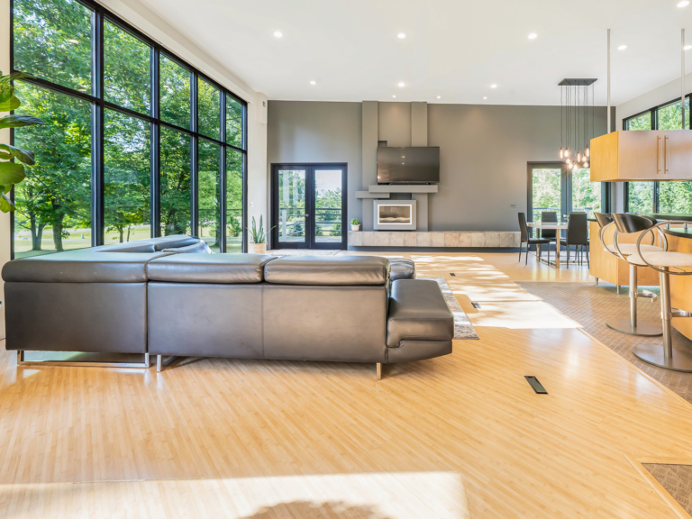 View of fireplace and open floor plan living and dining space of modern renovation home project by The RBT Group.