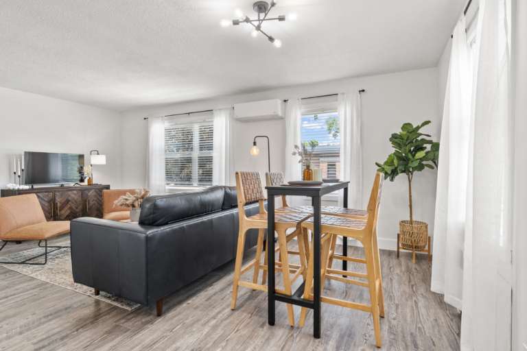 Living space with large windows bringing in natural light of newly renovated and modern apartment at The RIV apartments in Fort Wayne, Indiana.