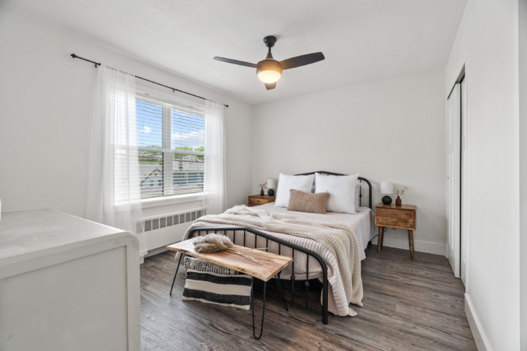 Bedroom with large window and natural light of newly renovated and modern apartment at The RIV apartments in Fort Wayne, Indiana.