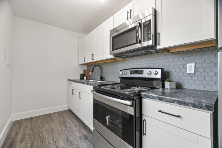 Kitchen space with ample counter space and modern backsplash of newly renovated apartment at The RIV apartments in Fort Wayne, Indiana.